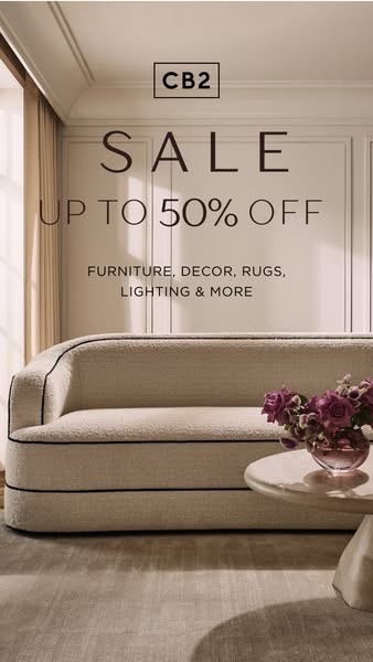 This ad features a staged living room with a cream colored sofa and a marble side table topped with flowers. The ad prom