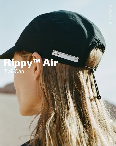 This ad highlights the Satisfy Ripppy™ Air Trail Cap, featuring a close-up image of the cap being worn outdoors.