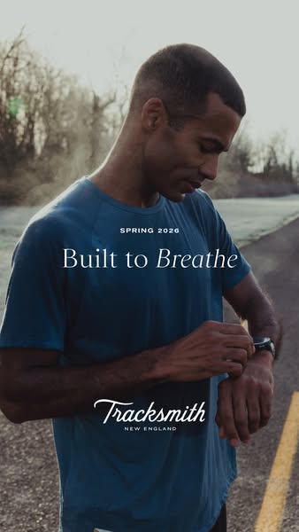 This image ad showcases a male runner wearing a Tracksmith t-shirt and checking his watch, set against an outdoor backdr