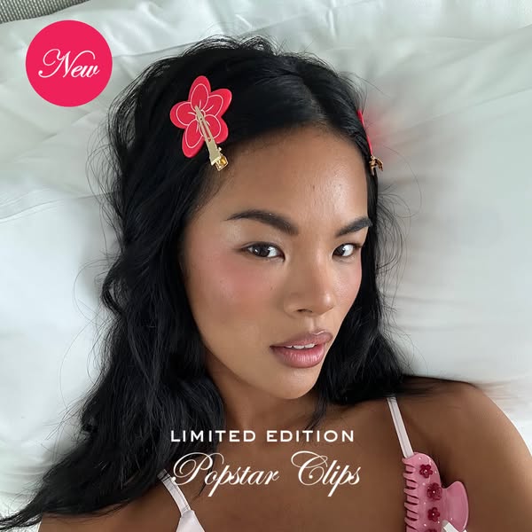 A woman lies in bed wearing flower hair clips. The ad highlights the new product release and suggests it's a limited