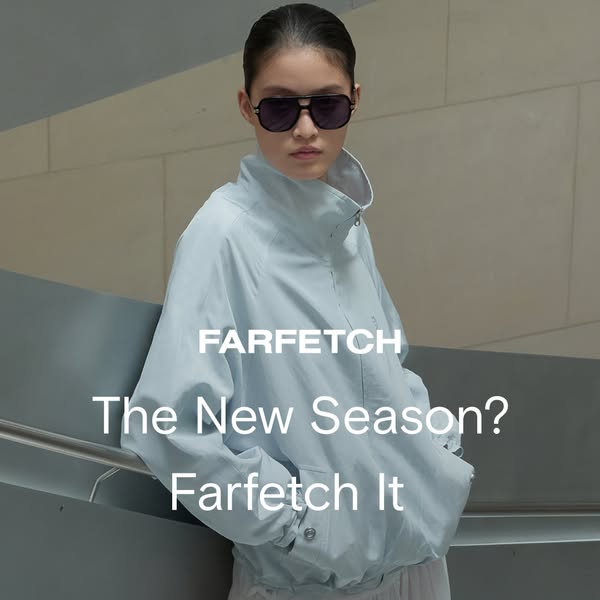 This ad for FARFETCH features a model in sunglasses and a light-blue jacket leaning against a grey wall. The ad is for t
