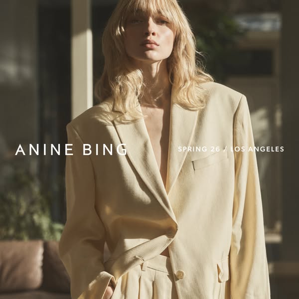 The ad features a high-fashion editorial style image of a female model wearing a Spring 2026 suit by Anine Bing. The vis