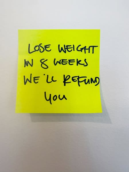 Image ad showing a yellow sticky note on a white wall with the text "Lose weight in 8 weeks, we'll refund you&q