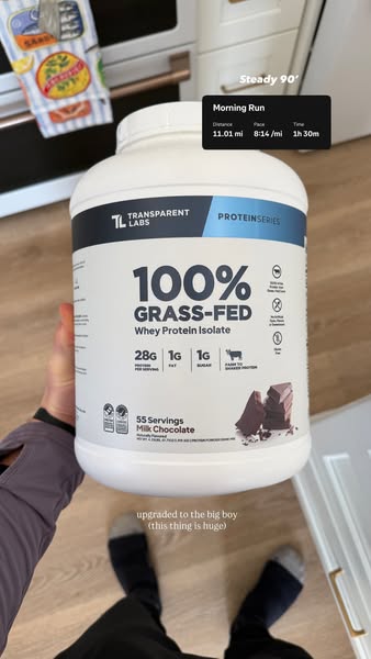 This ad features a person displaying a large container of Transparent Labs 100% Grass-Fed Whey Protein Isolate, specific