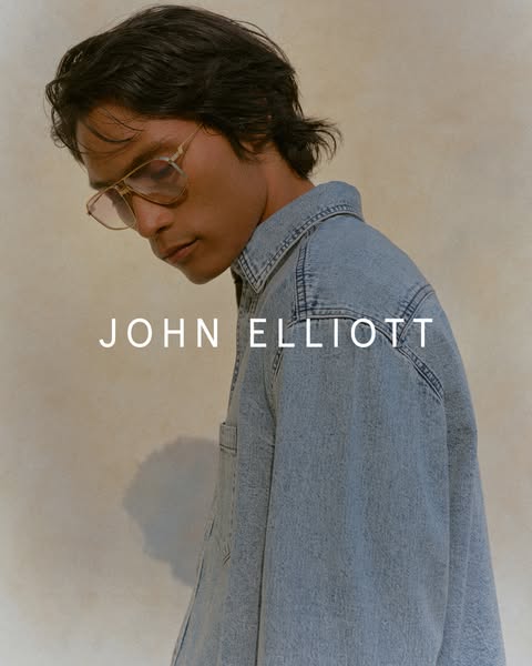 This ad features a person with glasses and a denim shirt. The ad promotes the brand JOHN ELLIOTT.