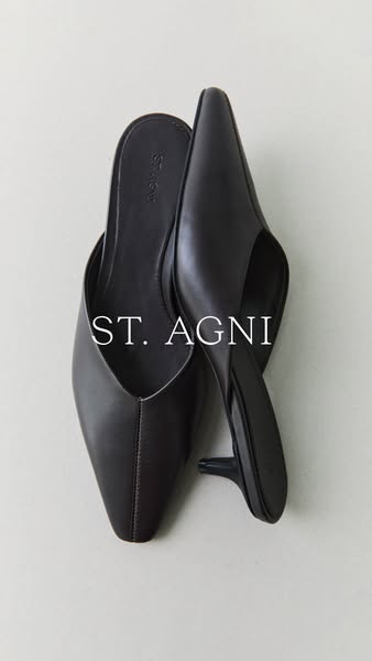 This ad features a pair of black ST. AGNI heeled mules. The ad focuses on the product and its minimalist design.