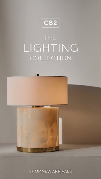 This ad by CB2 showcases an alabaster table lamp. The ad encourages viewers to shop new arrivals from the lighting colle