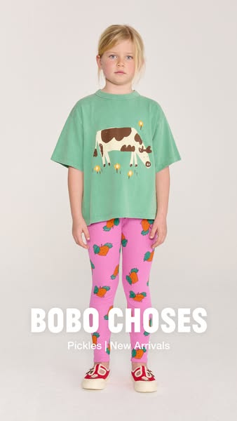 This ad is for Bobo Choses and features a young girl wearing a shirt with a cow print, pants with a carrot print, and re