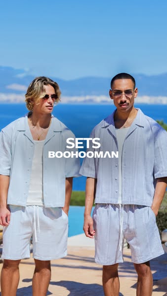 This ad for Boohooman features two men wearing matching sets, standing in front of a beach.