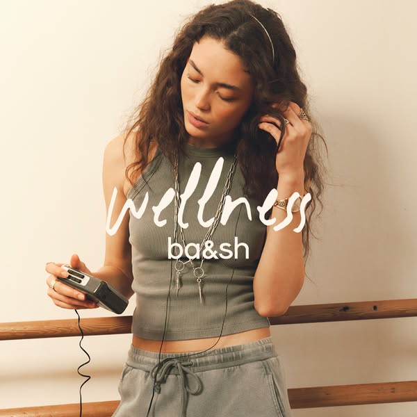 Image ad for ba&sh apparel and accessories. The image shows a woman in ba&sh apparel listening to music on a por