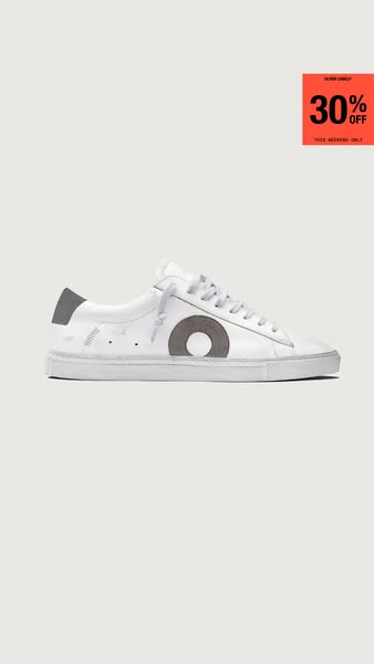 This ad promotes a pair of white low-top sneakers from the brand Oliver Cabell. The image showcases one shoe against a s
