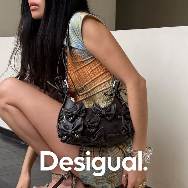 This ad features a woman crouching and holding a Desigual purse.