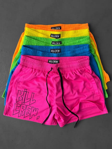 This image ad showcases a stack of KILLCREW brand shorts in various neon colors on a grey background. The ad uses a prod
