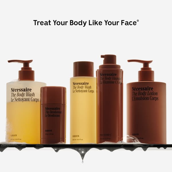 This image ad showcases a range of Nécessaire body care products displayed on a shelf with foamy water. The headline emp
