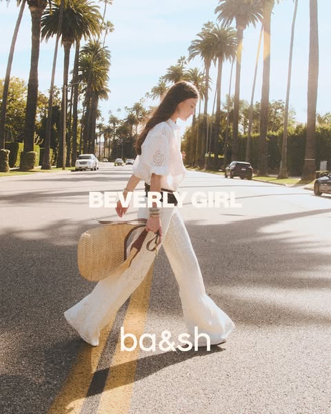 This ad shows a woman in summery clothing walking across a street in Beverly Hills. The brand is using an aesthetic that