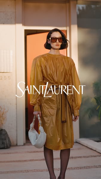 This ad showcases Saint Laurent clothing and handbag. The model is wearing the clothes and holding the bag.