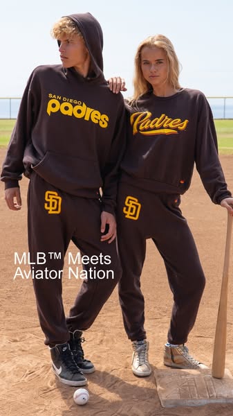 Image shows 2 models, one male and one female, in a baseball field type environment wearing San Diego Padres branded mat