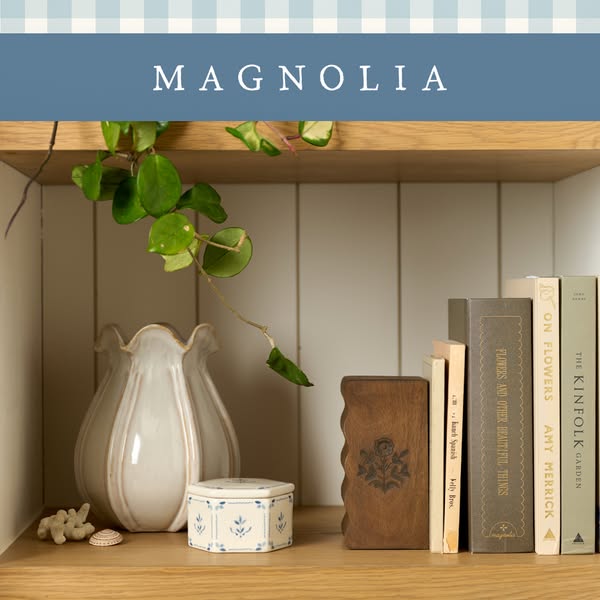 This ad features an image of Magnolia brand products artfully arranged on a wooden shelf. The scene includes a decorativ