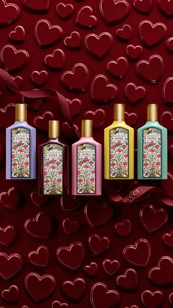 An advertisement for Gucci Flora perfume features 5 different bottles of the perfume against a red background with red h