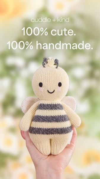 This image ad features a close-up of a handmade bee plush toy being held by a hand, with a background of blurred flowers