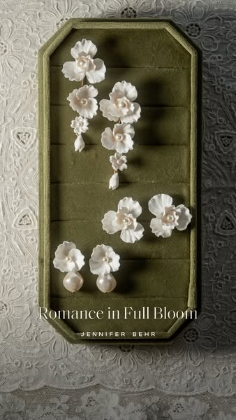 This image ad showcases floral earrings by Jennifer Behr. The ad features the product arranged on a green velvet surface