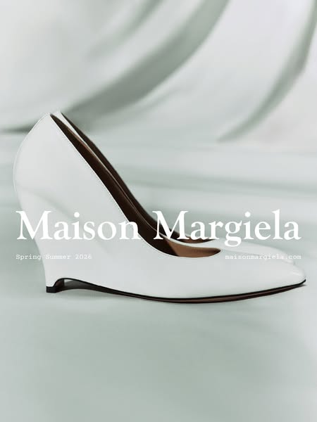 This ad features a single white wedge heel from Maison Margiela in a studio setting. The ad showcases the shoe's des