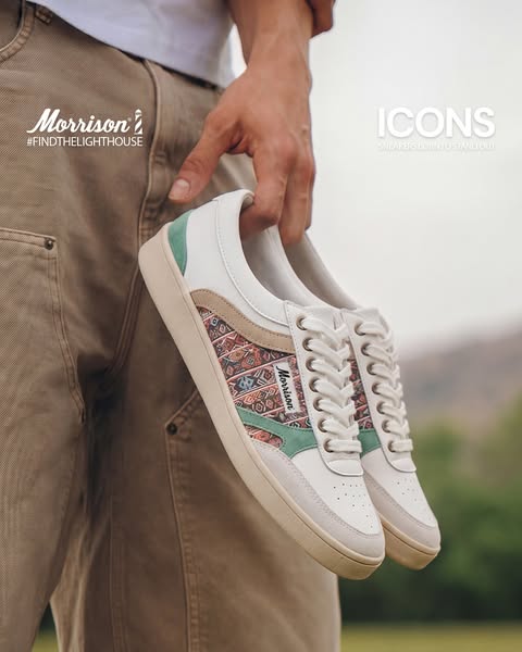 An ad for Morrison shoes featuring a man holding two of the brand's sneakers.