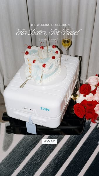This ad showcases a white Away suitcase topped with a heart-shaped cake and champagne flutes, as well as a pink and red 