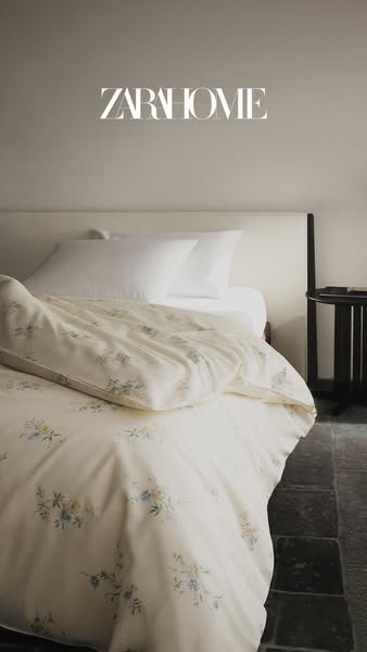 A minimalist image ad from Zara Home featuring a bed with floral pattern bedding, showcasing the brand's aesthetic o