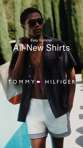 A close-up shot of a man with a duffel bag over his shoulder, advertising Tommy Hilfiger's all-new shirts for the ea