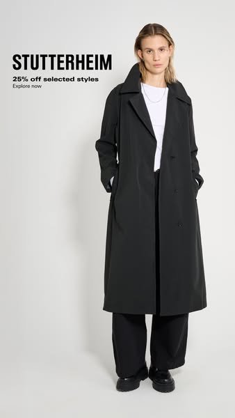 This image ad for Stutterheim features a woman wearing a black trench coat, presenting the product in a clean and minima