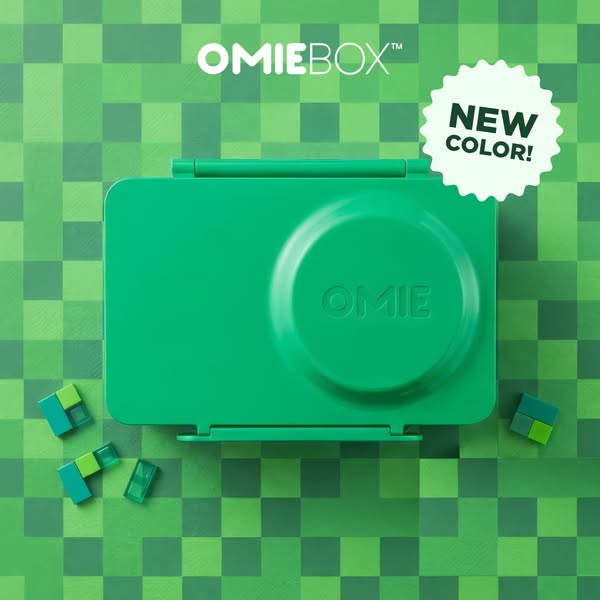 This ad features a green OmieBox lunchbox on top of a patterned green surface. The ad highlights the launch of a new col