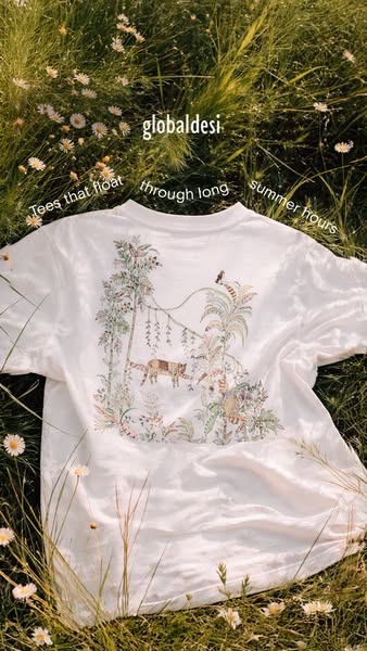 An ad for Global Desi t-shirts. The image features a white t-shirt with a jungle-themed design, laid out on a bed of gra