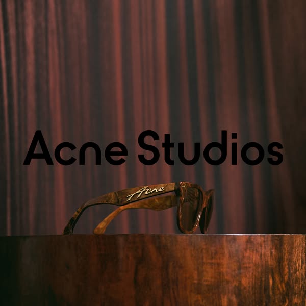This ad by Acne Studios showcases their eyewear product on a wooden surface with an artistic dark background to capture 