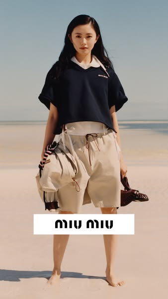 This ad showcases a Miu Miu apparel outfit with a navy top, beige shorts, and sandals on a beach setting. The ad promote