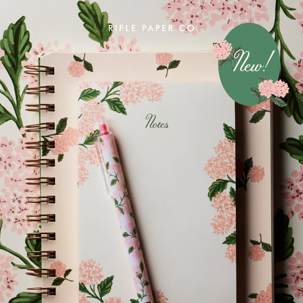 This ad showcases Rifle Paper Co. stationery products including a spiral notebook, a paper notepad, and a matching pen i