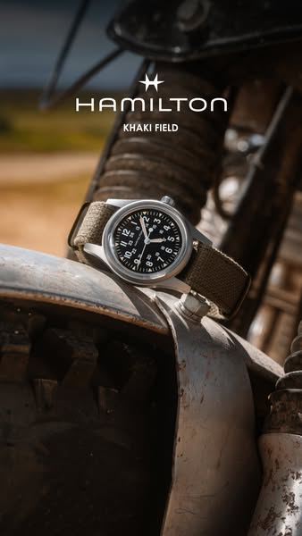 The image ad features the Hamilton Khaki Field watch resting on a motorcycle part to show off the brand's quality an