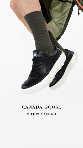 This image ad showcases a pair of black leather Canada Goose sneakers with a white sole. The sneakers are presented bein