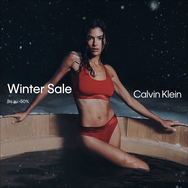 This image ad for Calvin Klein features a woman in a red Calvin Klein bra and underwear set in a snowy, nighttime settin