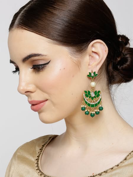 This image ad showcases a pair of green and gold earrings being worn by a model. The ad is likely targeted towards women