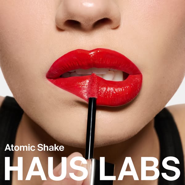 This image ad showcases the Haus Labs Atomic Shake lip gloss in action, highlighting its application and the resulting v