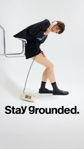 This ad shows a woman leaning over a chair while holding an old-fashioned telephone to her ear. The woman is wearing a d