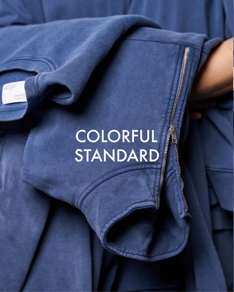 This ad features a close-up of a blue Colorful Standard sweatshirt, emphasizing its quality and design.