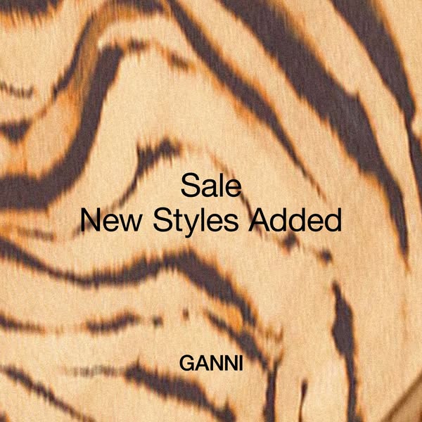 This image ad for GANNI features a close-up of a tiger-striped pattern with the text "Sale New Styles Added" a
