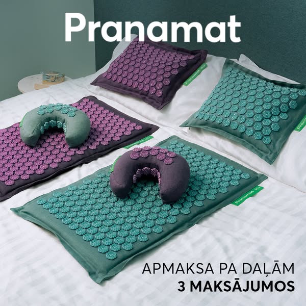 A display of Pranamat acupressure mats in two color variations on a bed with white sheets. The pillows are also shown. T