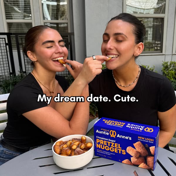 This image ad features two women on what appears to be a date, eating Auntie Anne's Cinnamon Sugar Pretzel Nuggets a