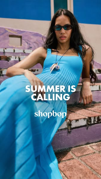 An image ad features a woman reclining on a set of outdoor stairs wearing a bright blue maxi dress. The ad is promoting 