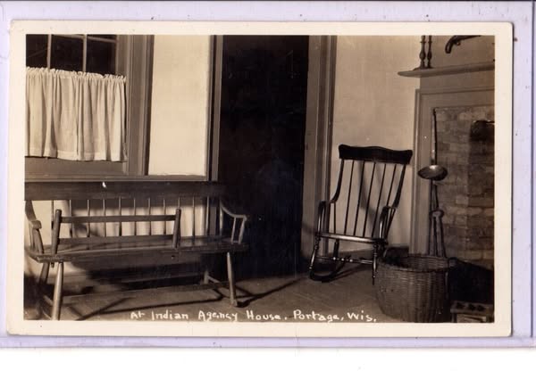 This is a black and white image of the Indian Agency House in Portage, Wisconsin. The image shows a bench, rocking chair