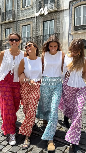 An image ad showcasing a brand's skirts worn by multiple women outdoors in front of a patterned building.