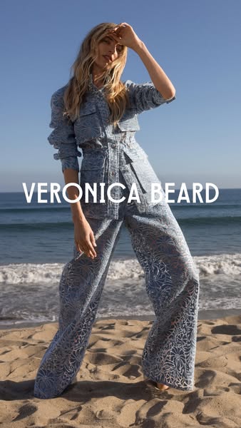 An outdoor shot of a model wearing a matching denim jacket and pants set with the brand name overlaid. The style is aspi